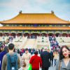紫禁城の前で記念撮影をする一人旅の女性と大勢の観光客